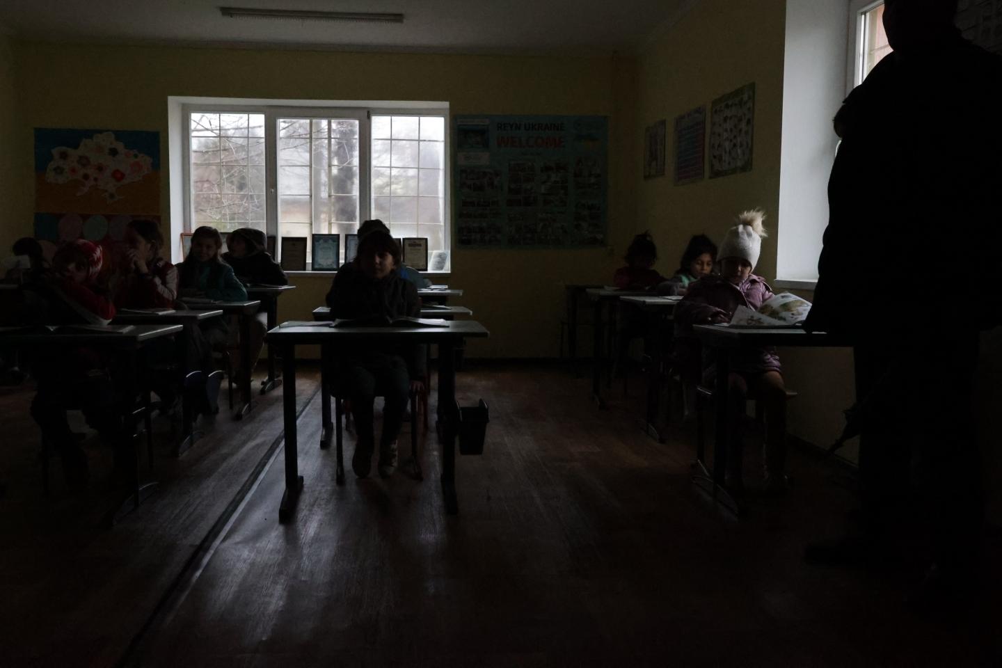 Children sitting a dark classroom