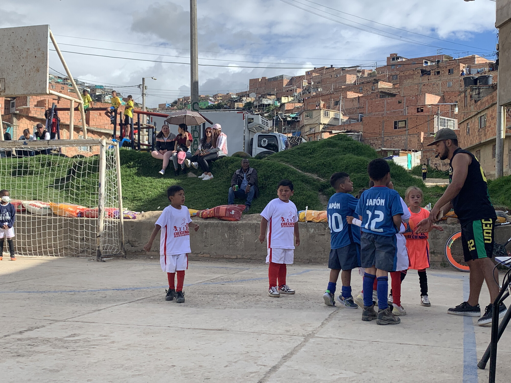 A coach works with kids at on a soccer pitch in a school yard in Colombia.