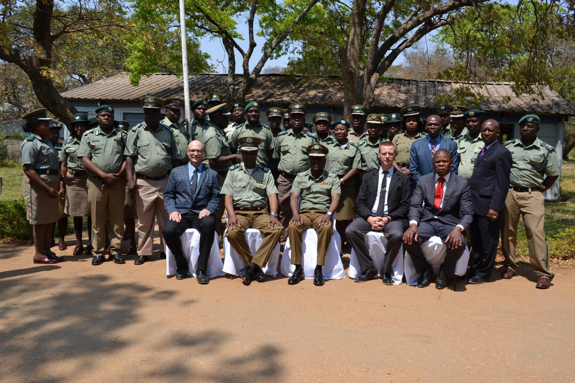 A group of Zambian correctional officers pose for a photo with visitors from Canada.