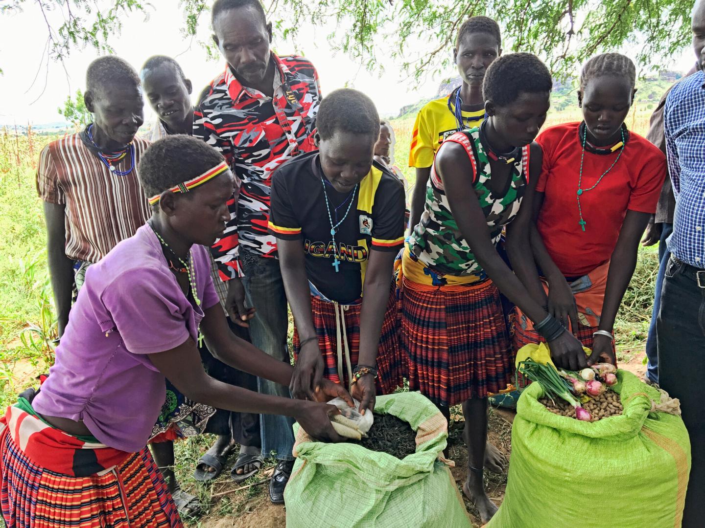 A group in Uganda open large bags of grain and dried beans