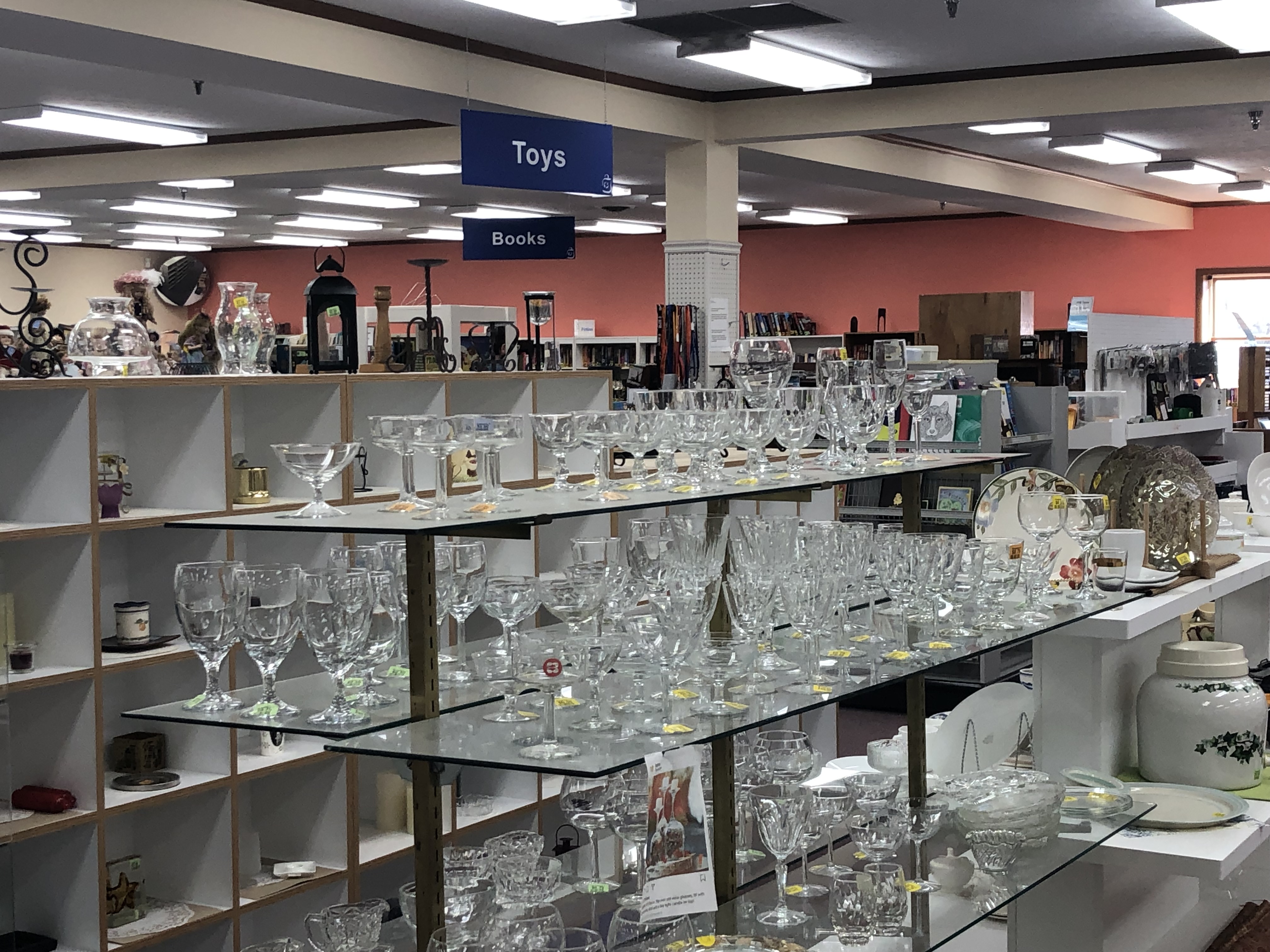 thrift shop display with rows of clear drinking glasses 