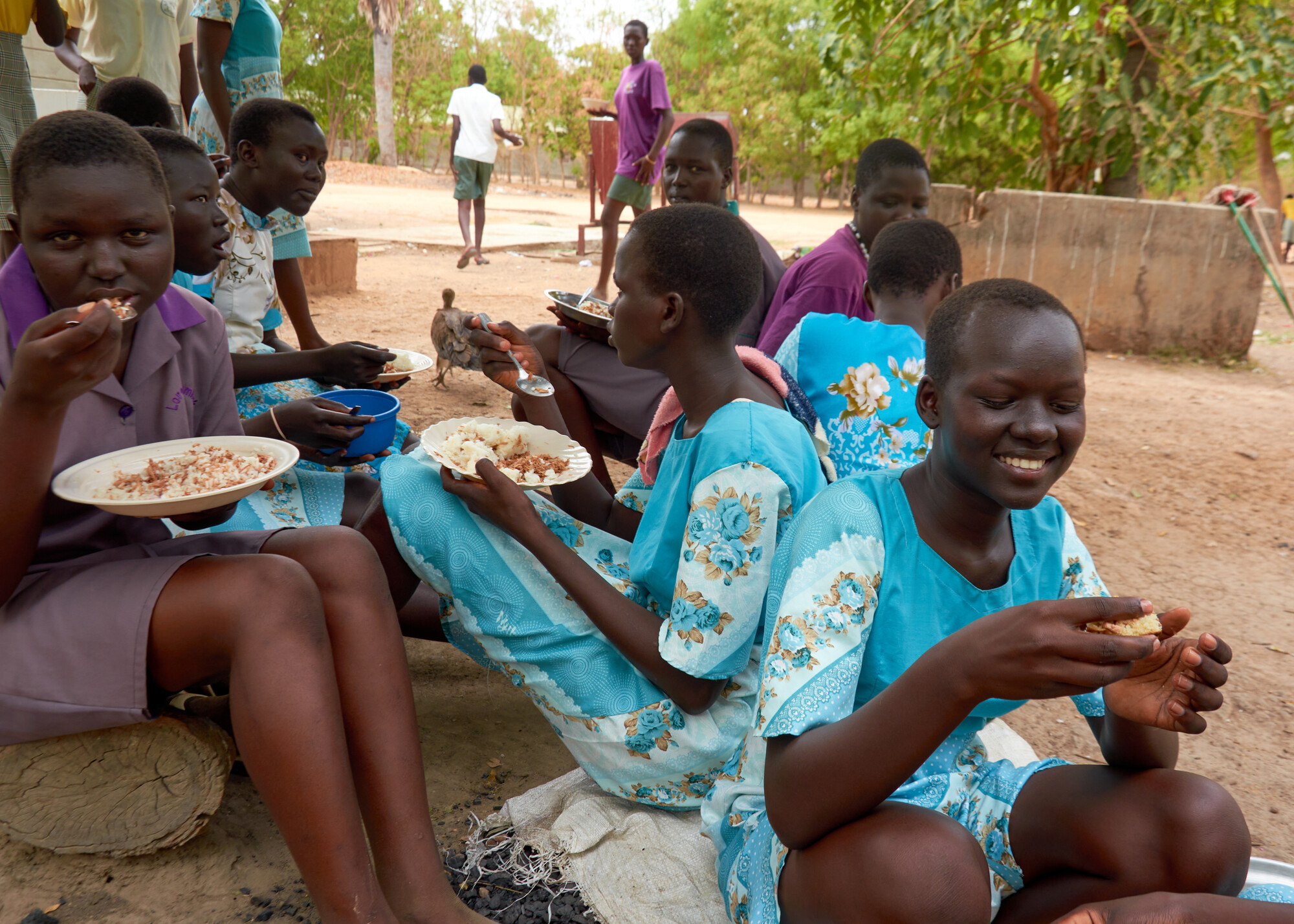 A group of young women eat a meal outside