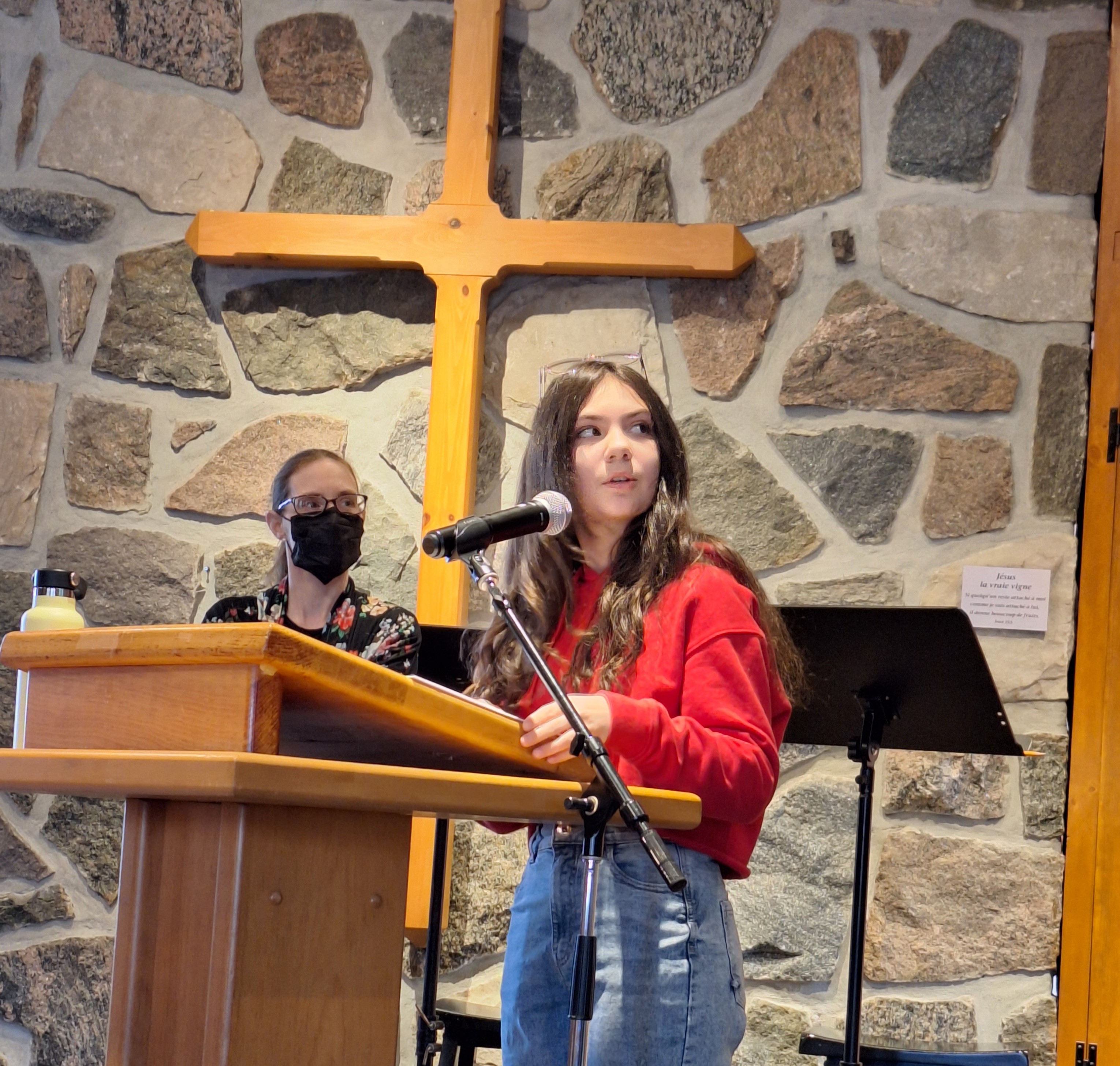 A young woman speaking in front of a church