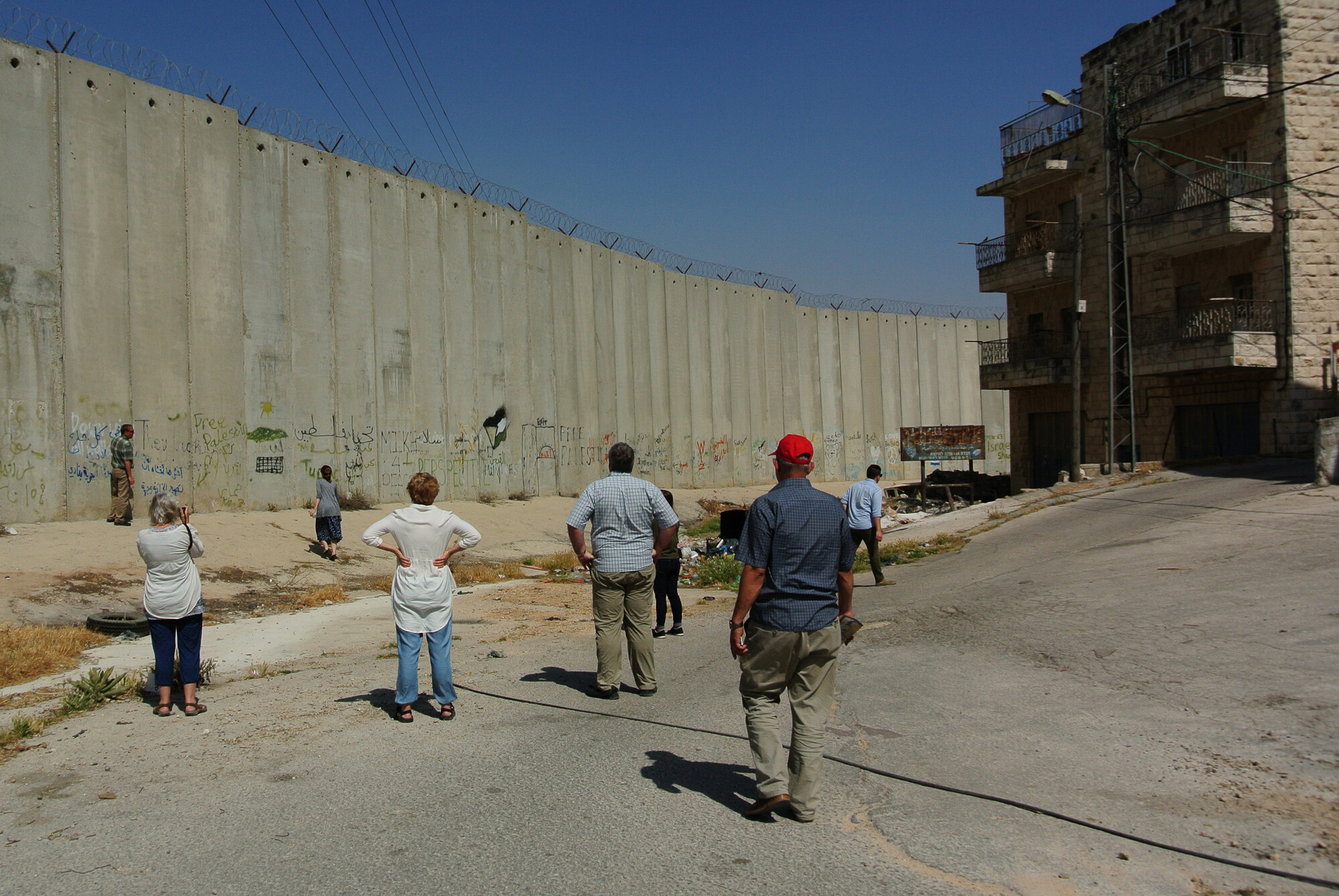 A group of people near the Palestine-Israel border wall