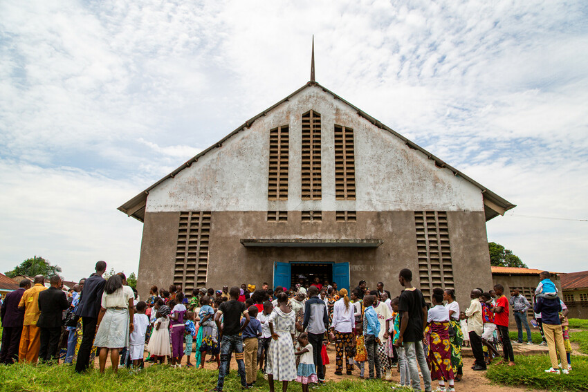 After a Sunday morning worship service, people visit together outside the CEFMC Kimpwanza Kikongophone parish in the city of Kikwit in the Democratic Republic of the Congo. Justin Makangara/MCC/Fairpi