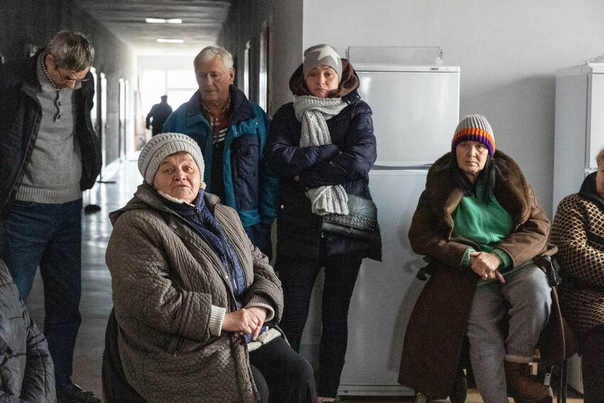 Residents living in a shelter on the second floor of a former hospital in Mukachevo, Ukraine, attend a meeting. Margaryta (right), whose full name is withheld for security reasons, is an AMBCU volunte