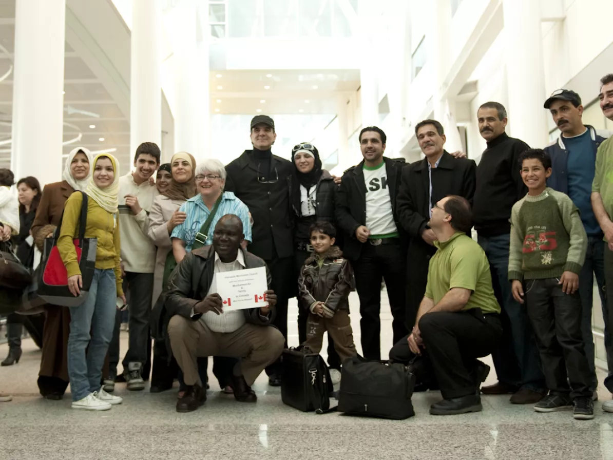 A large group of people pose together at an airport