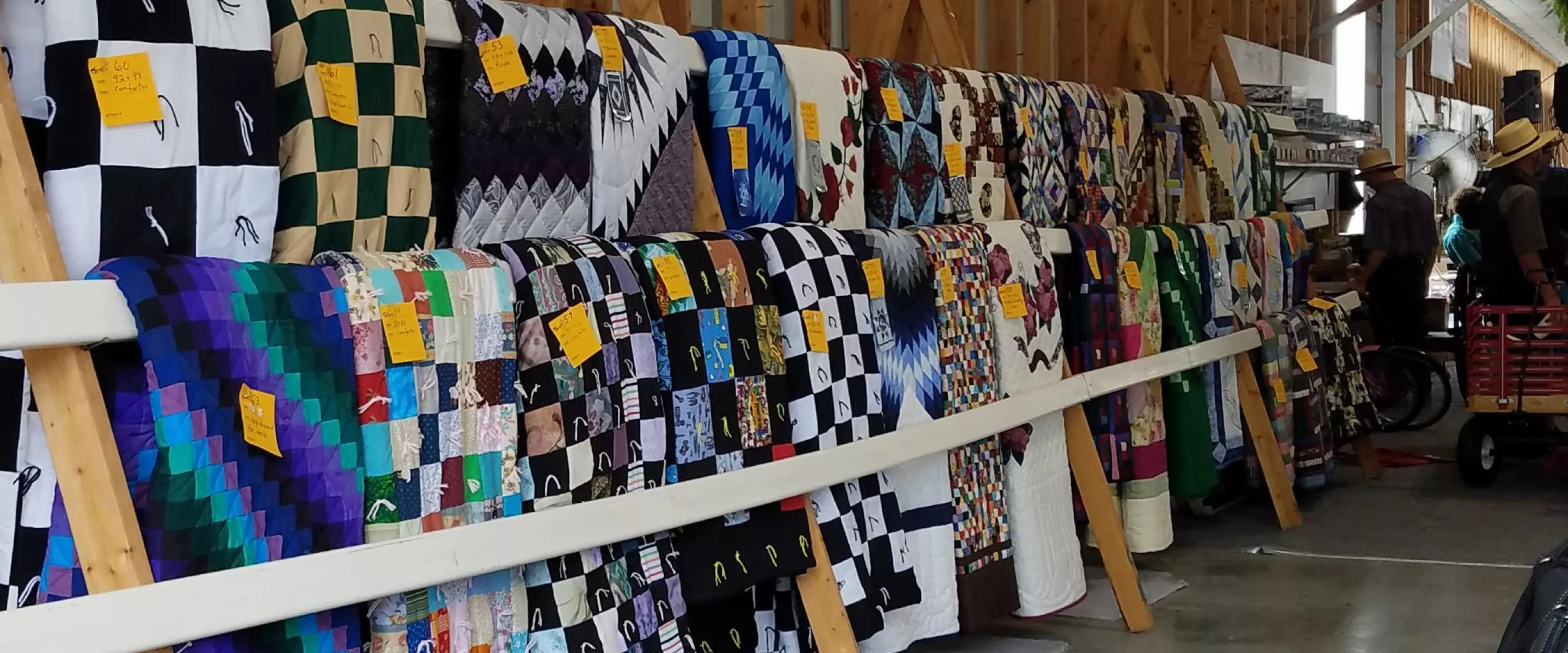 A large number of quilts on display before an auction