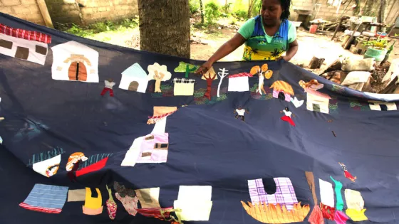 In 2010, Mampuján community leader Juana Alicia Ruíz Hernández displays a partially completed 10-year historic quilt project in Colombia celebrating the Mampuján community's past before they were disp