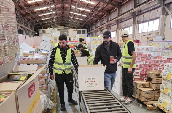 A group of people packing boxes of food relief for Gaza