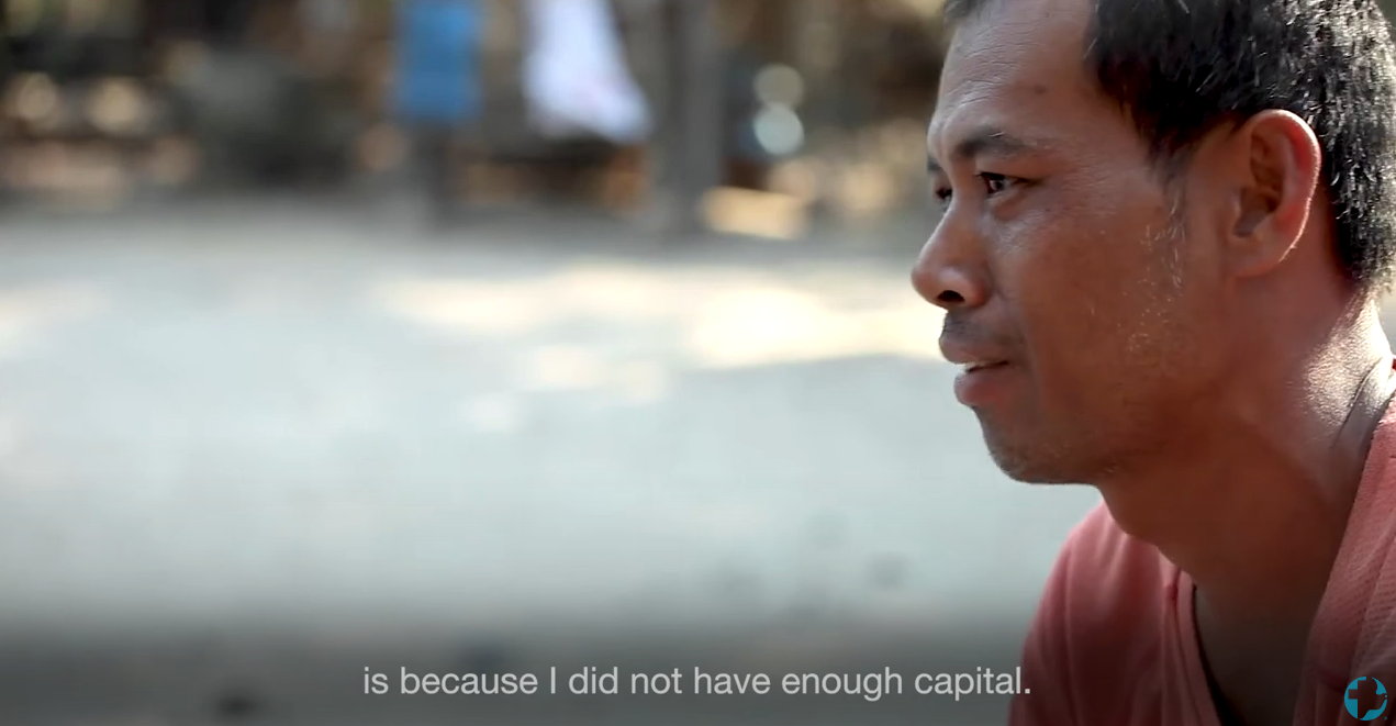 A Cambodian man in a pink shirt being interviewed