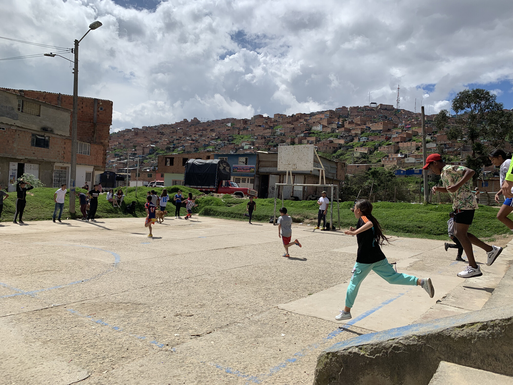 Children running onto a makeshift pitch in a school yard in Colombia.