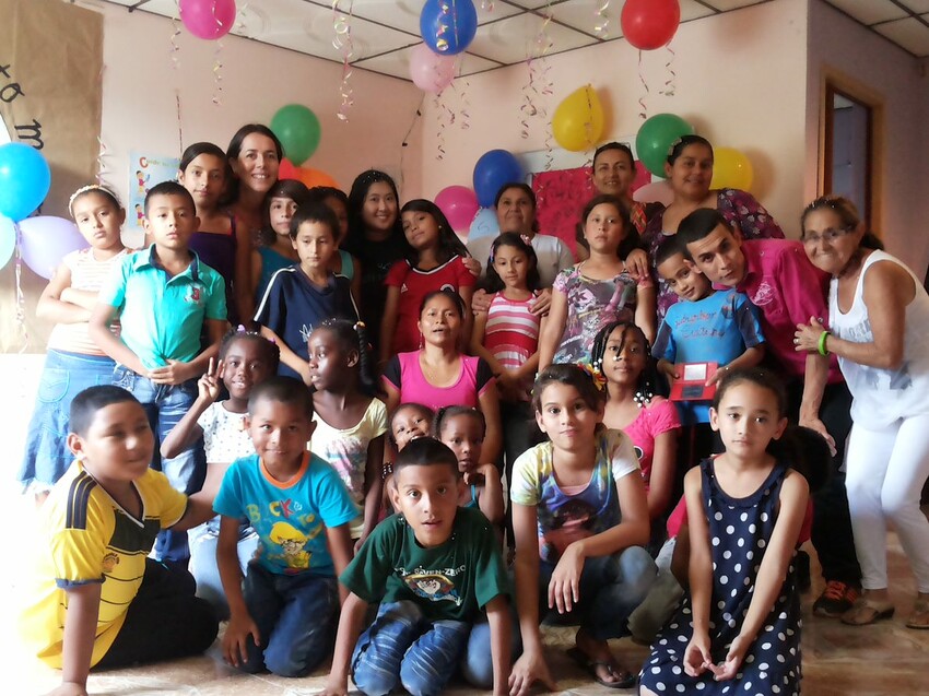 A group of mostly Colombian children surrounded by ballons.