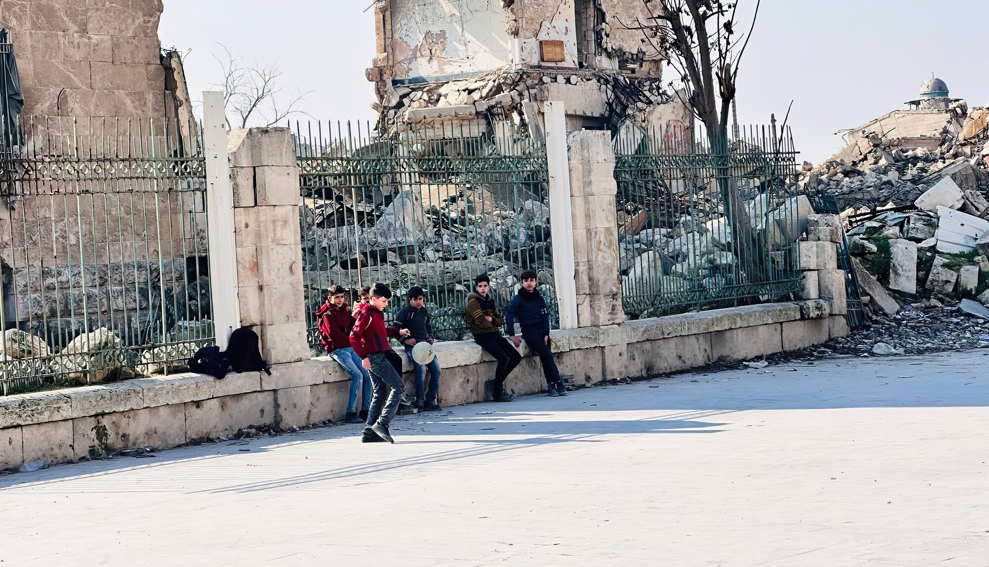 Young boys sitting in front of a ruined building