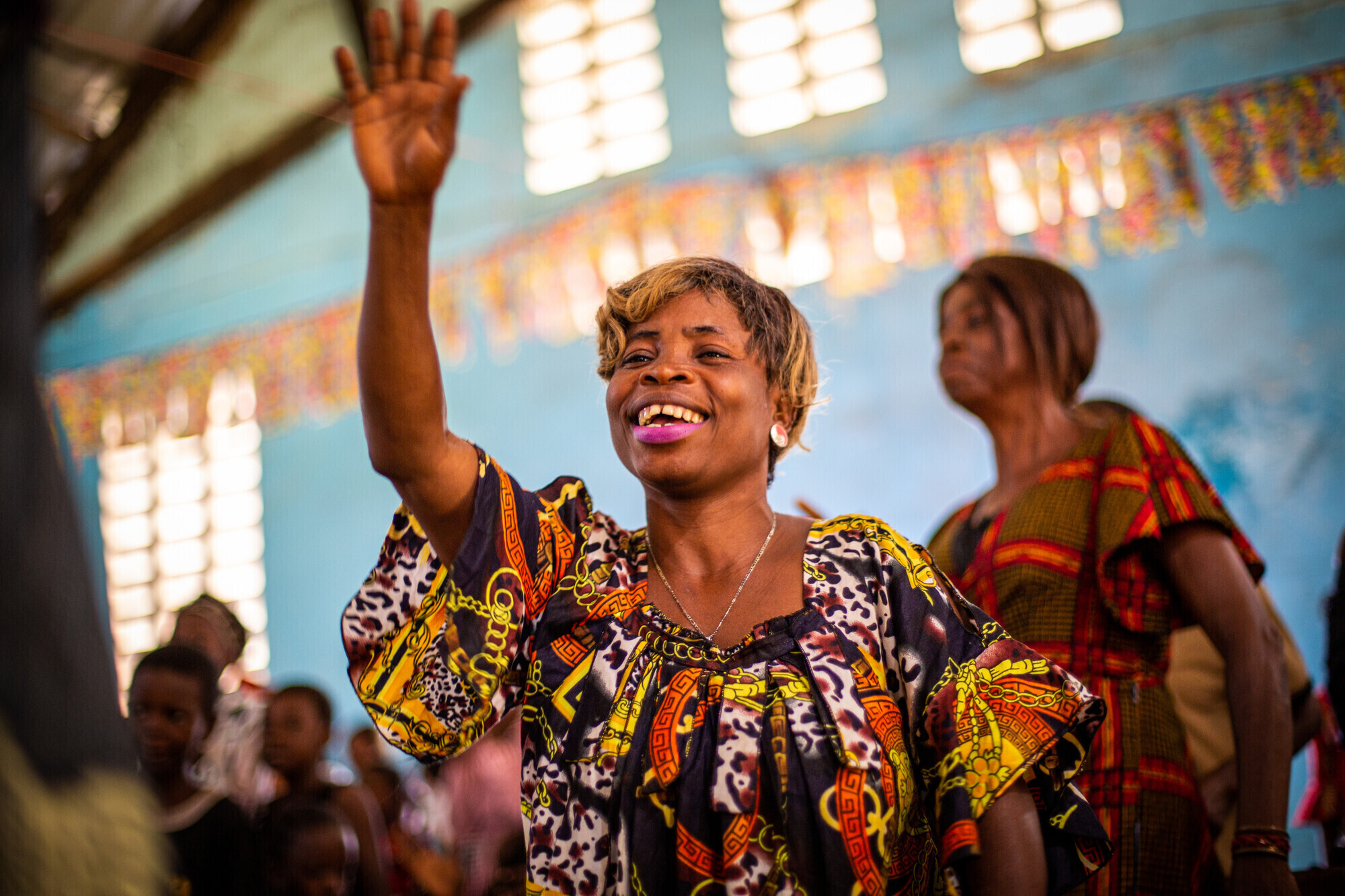 A woman with her arm raised in a church building