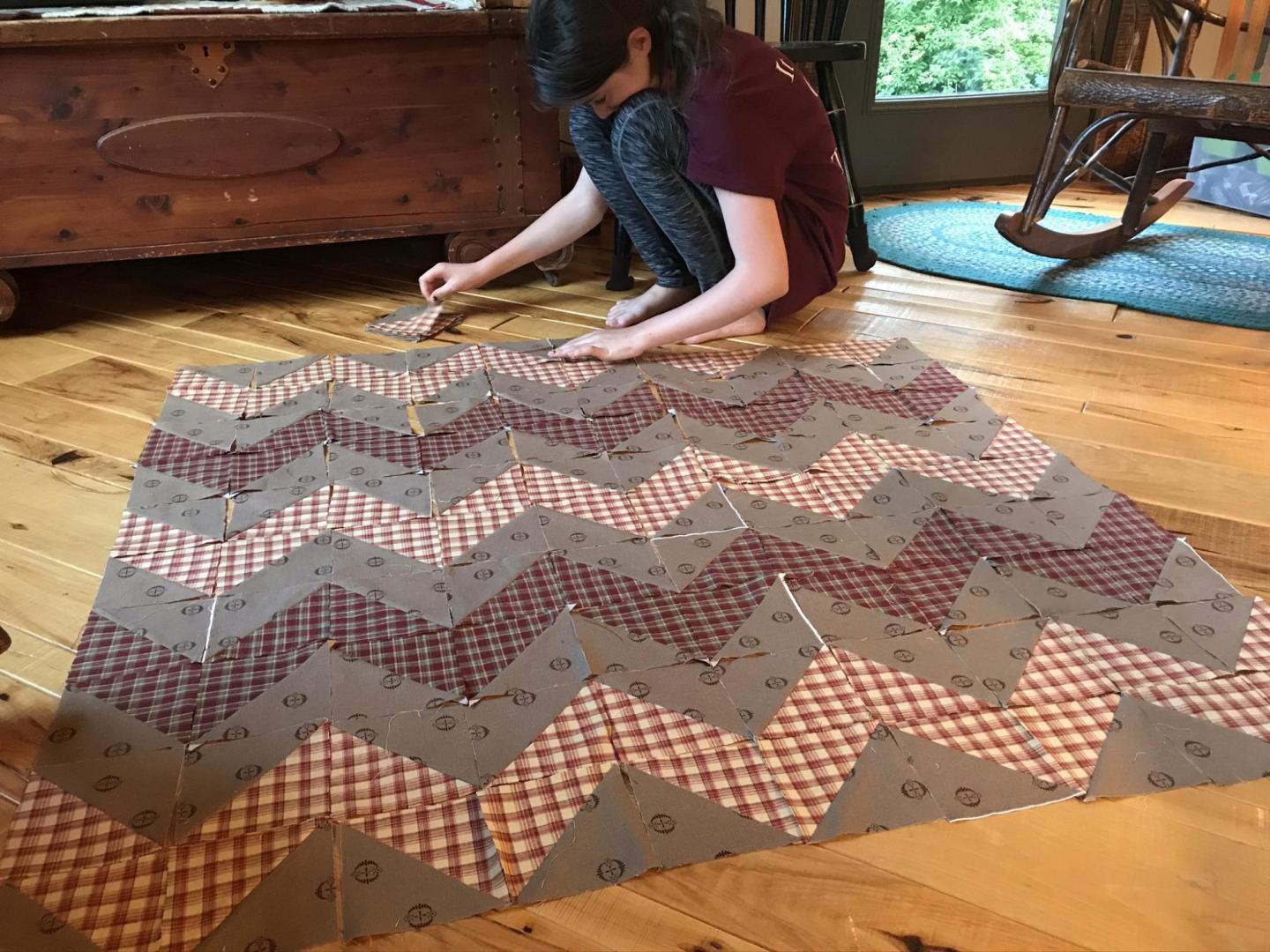 A young girl piecing together a quilt