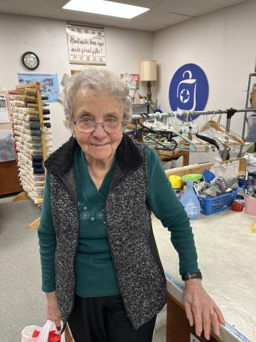 A woman smiling in an MCC thrift shop