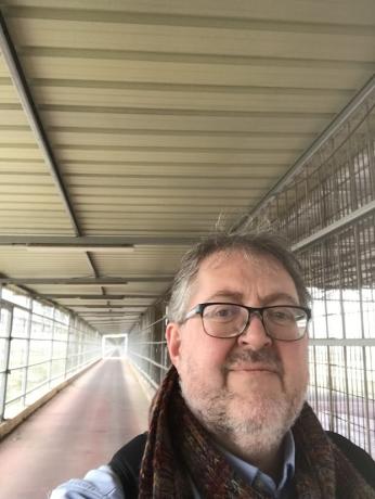 Alain taking a selfie photo in an enclosed walkway