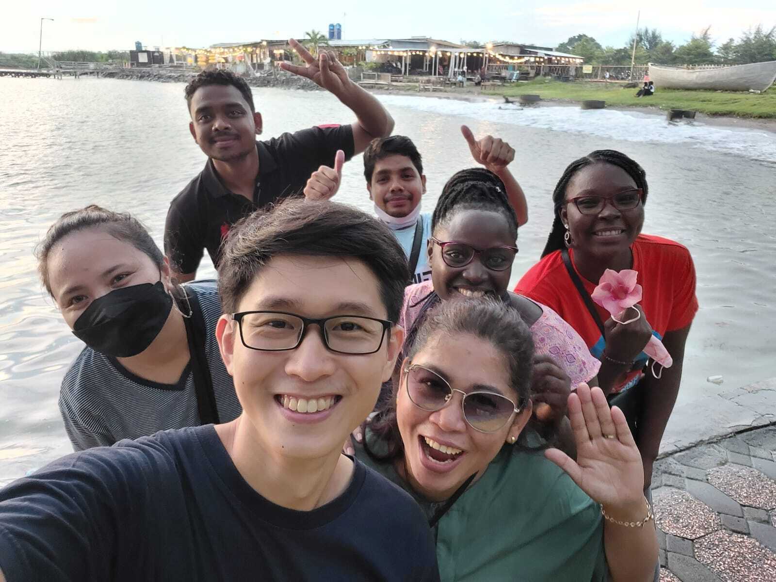 A group of seven people of different nationalities take a selfie together.