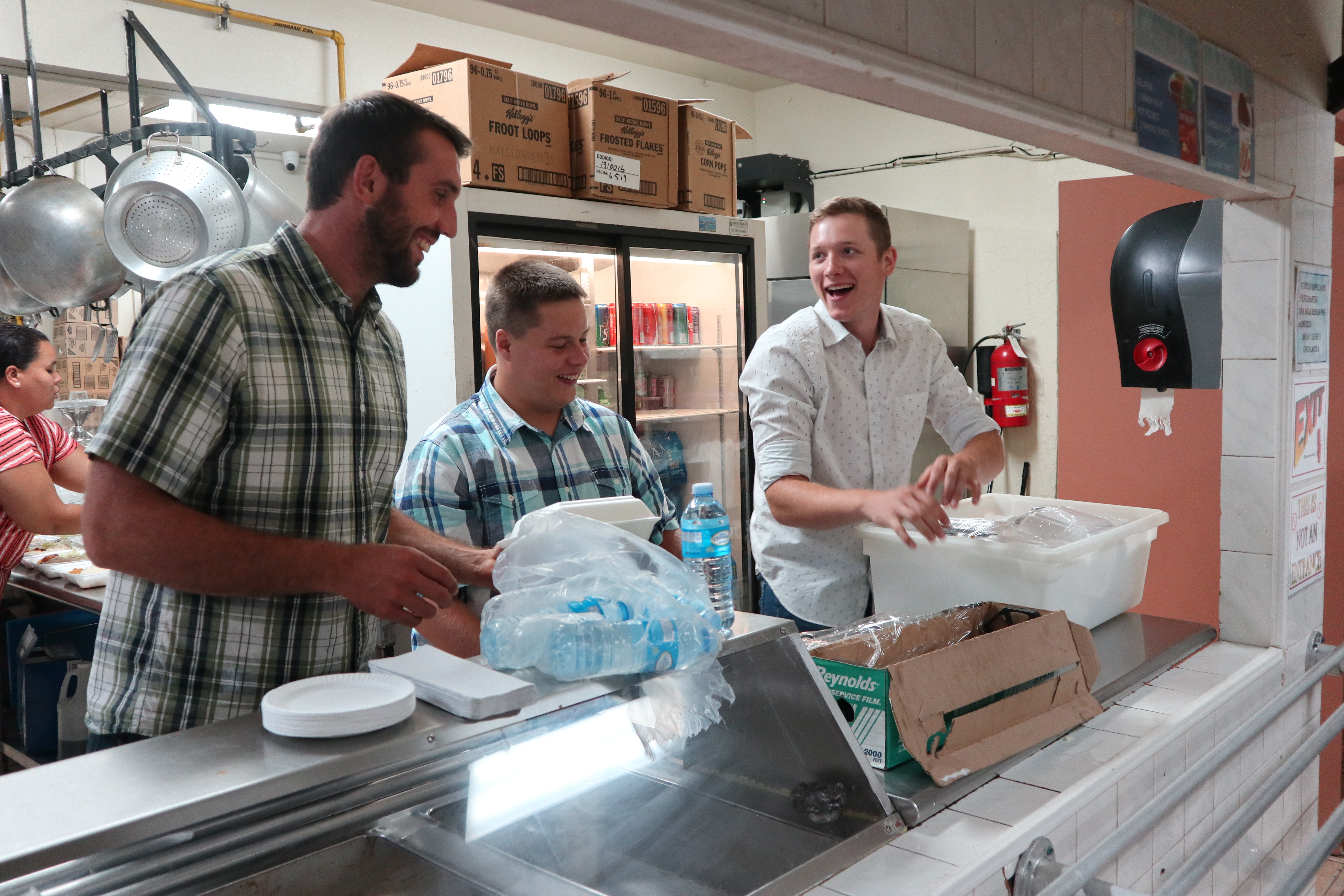 Three young men work together in a kitchen