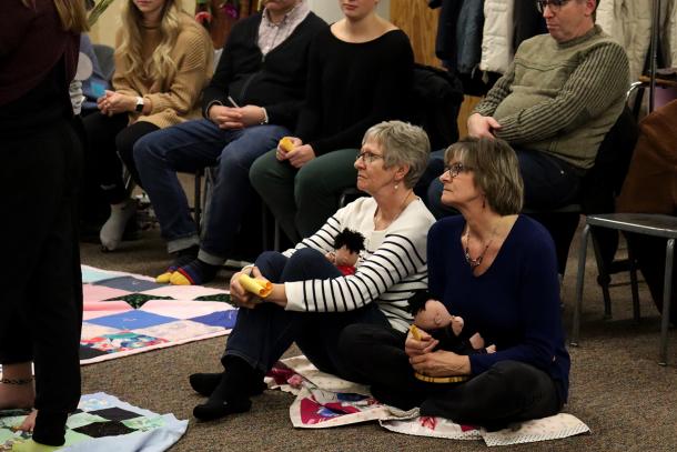 Anne Froese (left) and Nettie Strople sit on a crumbled blanket representing loss of land.