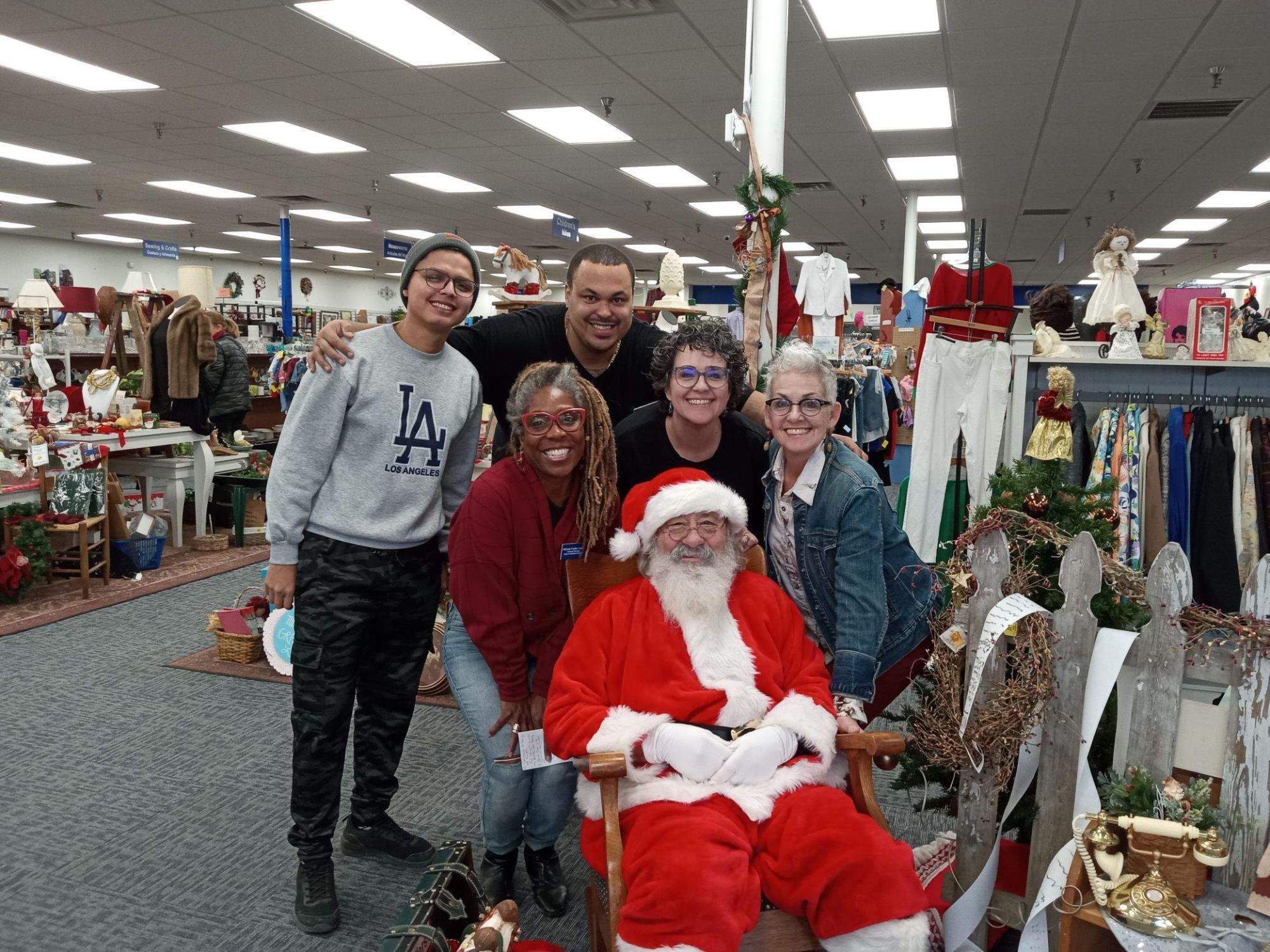 A group of people posing for a photo with Santa Claus