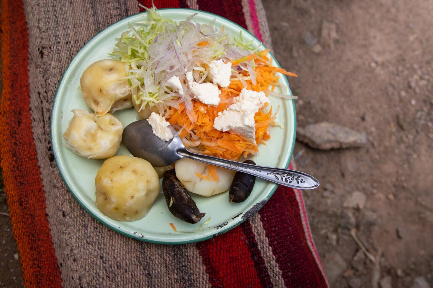 A plate and spoon with potatoes and salad