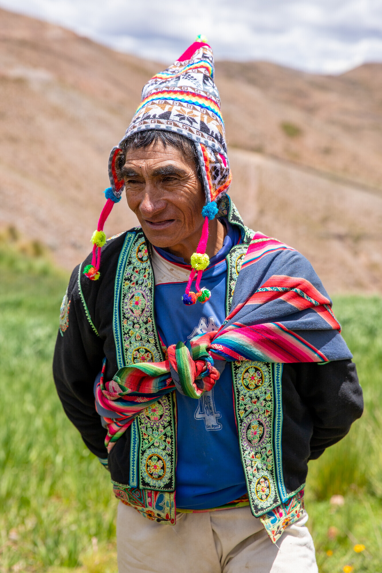 An Indigenous Bolivian man in a colorful, pointy hat 
