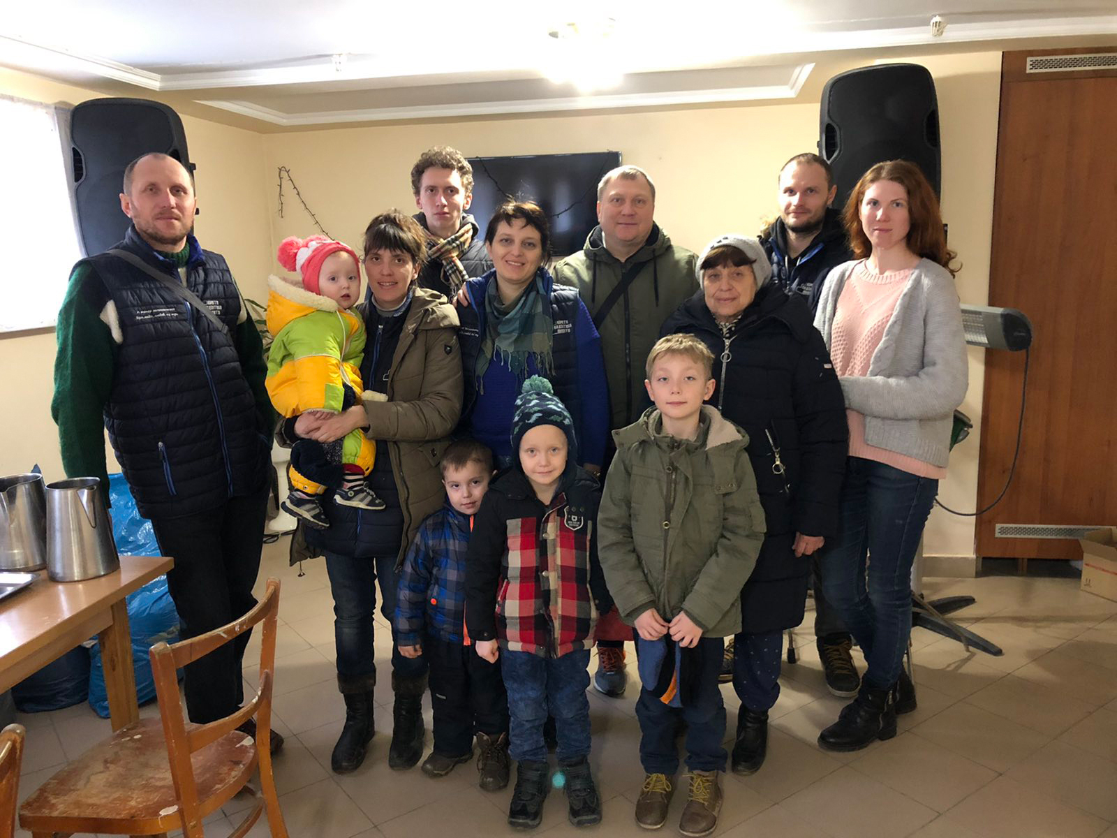 A group of Ukrainian adults and children stand together to take a photo.