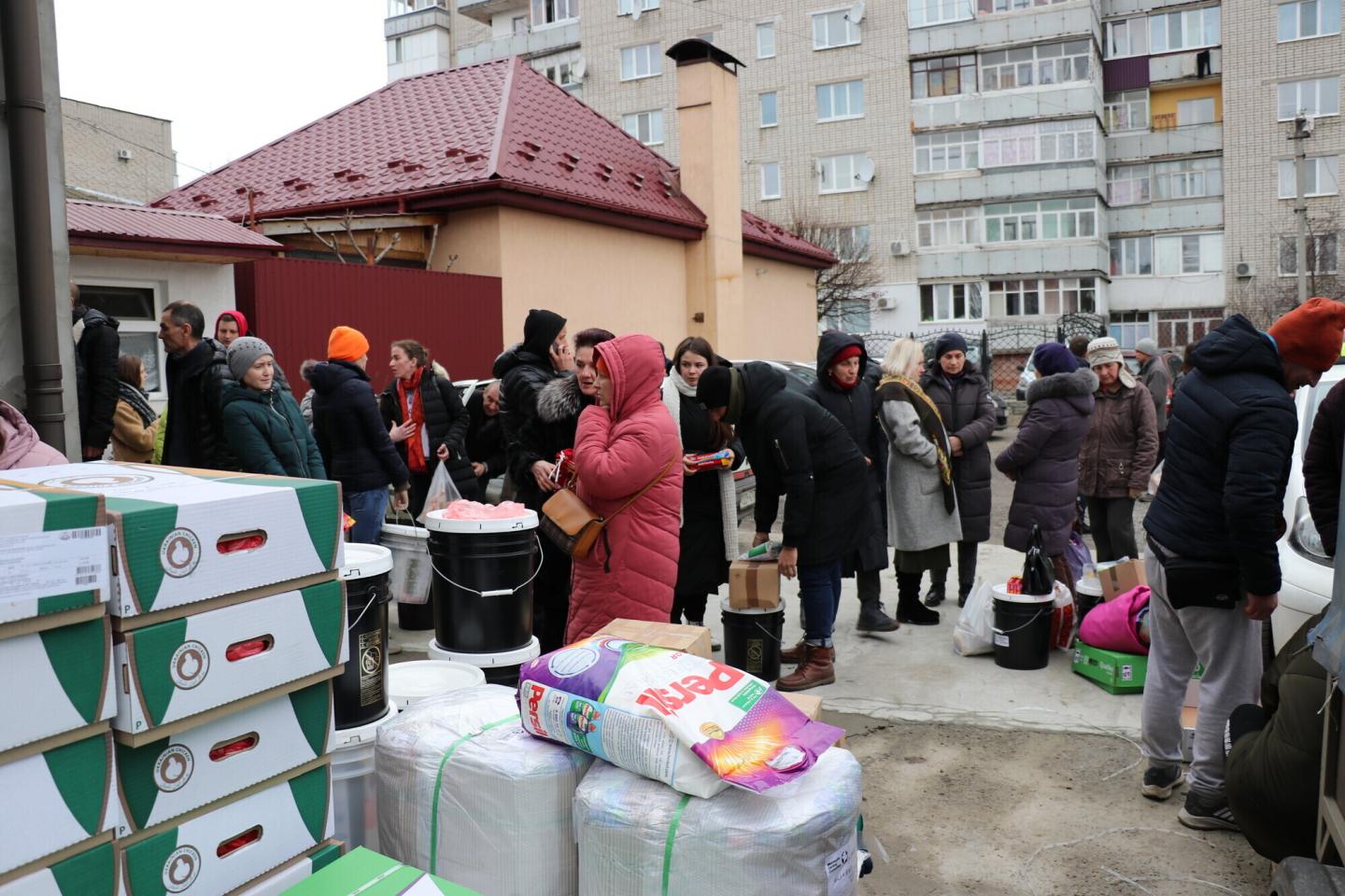 A group of Ukrainians in coats at a humanitarian aid distribution 