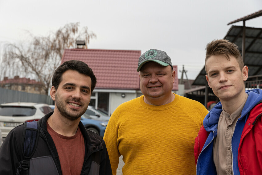 A group of three men smiling for a photo