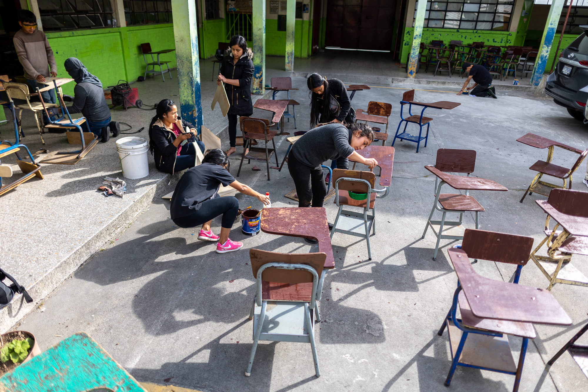 Students paint desks at José María Castilla School in Guatemala City.