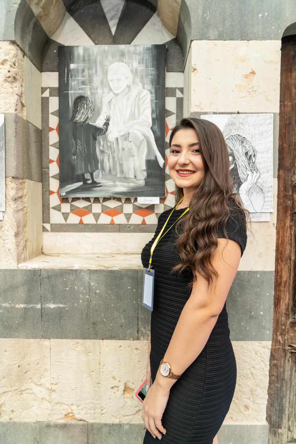 A young woman standing with a piece of art