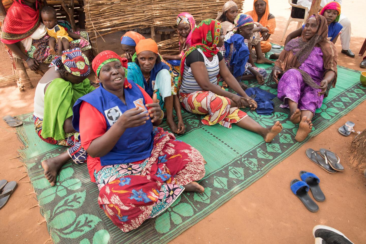 A group of Chadian women sit on a green mat