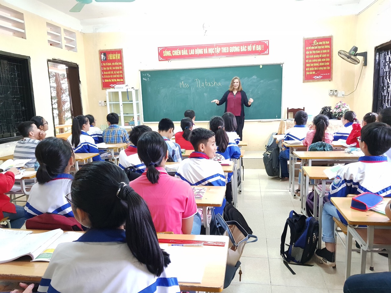A woman teaching a class of students at desks