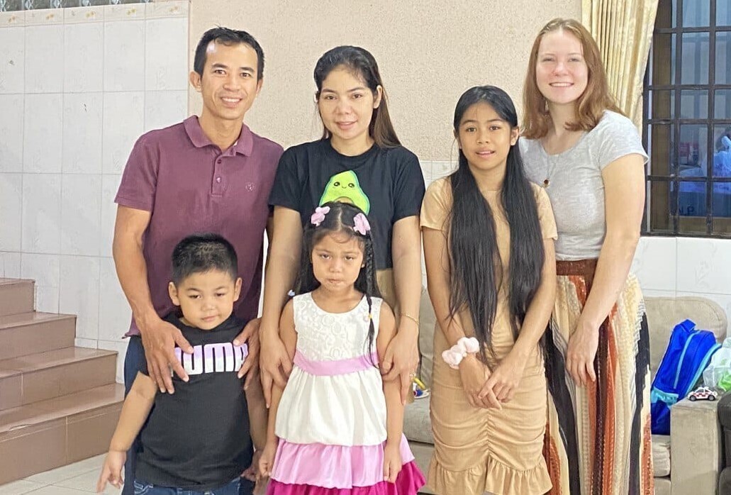 A man and two women stand with three children