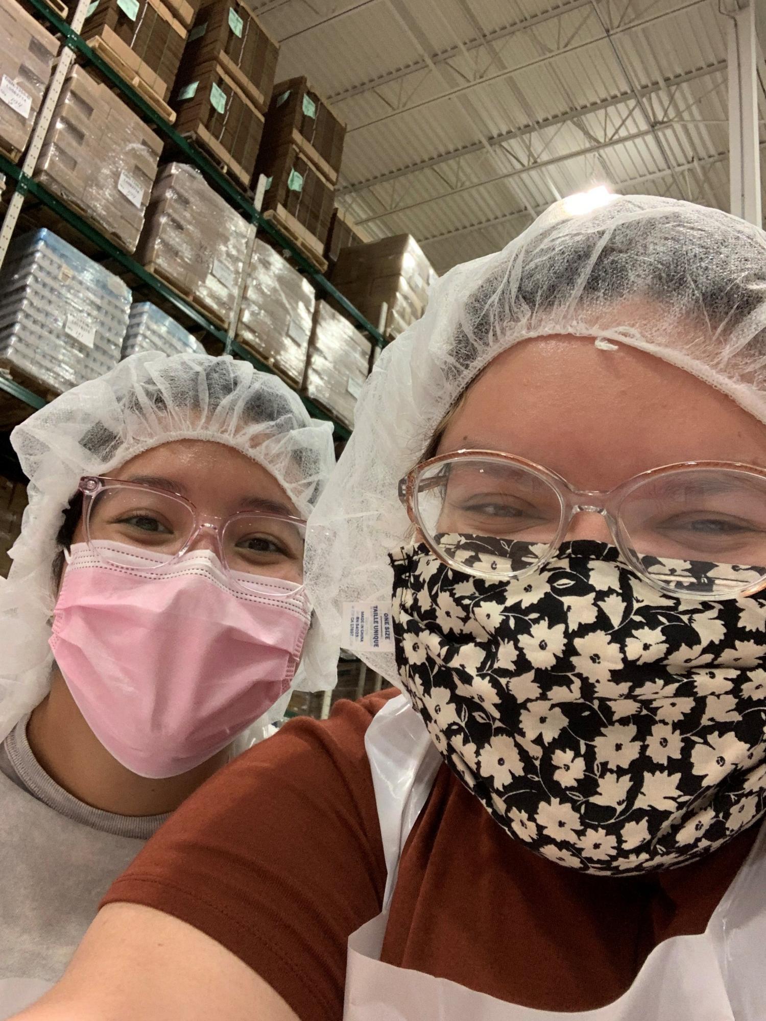 Two young women wearing hair nets in a warehouse