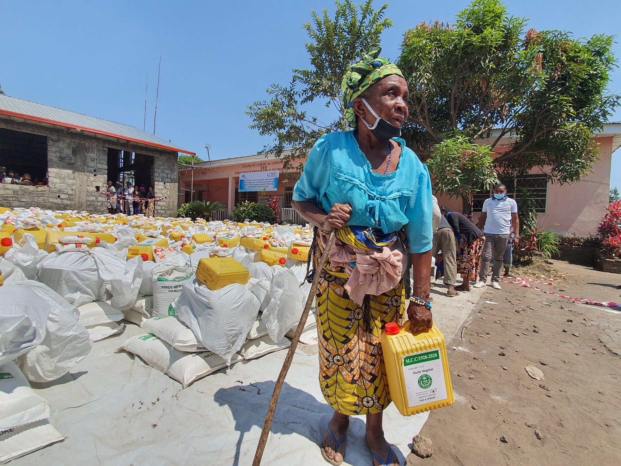 A woman standing next to relief supplies