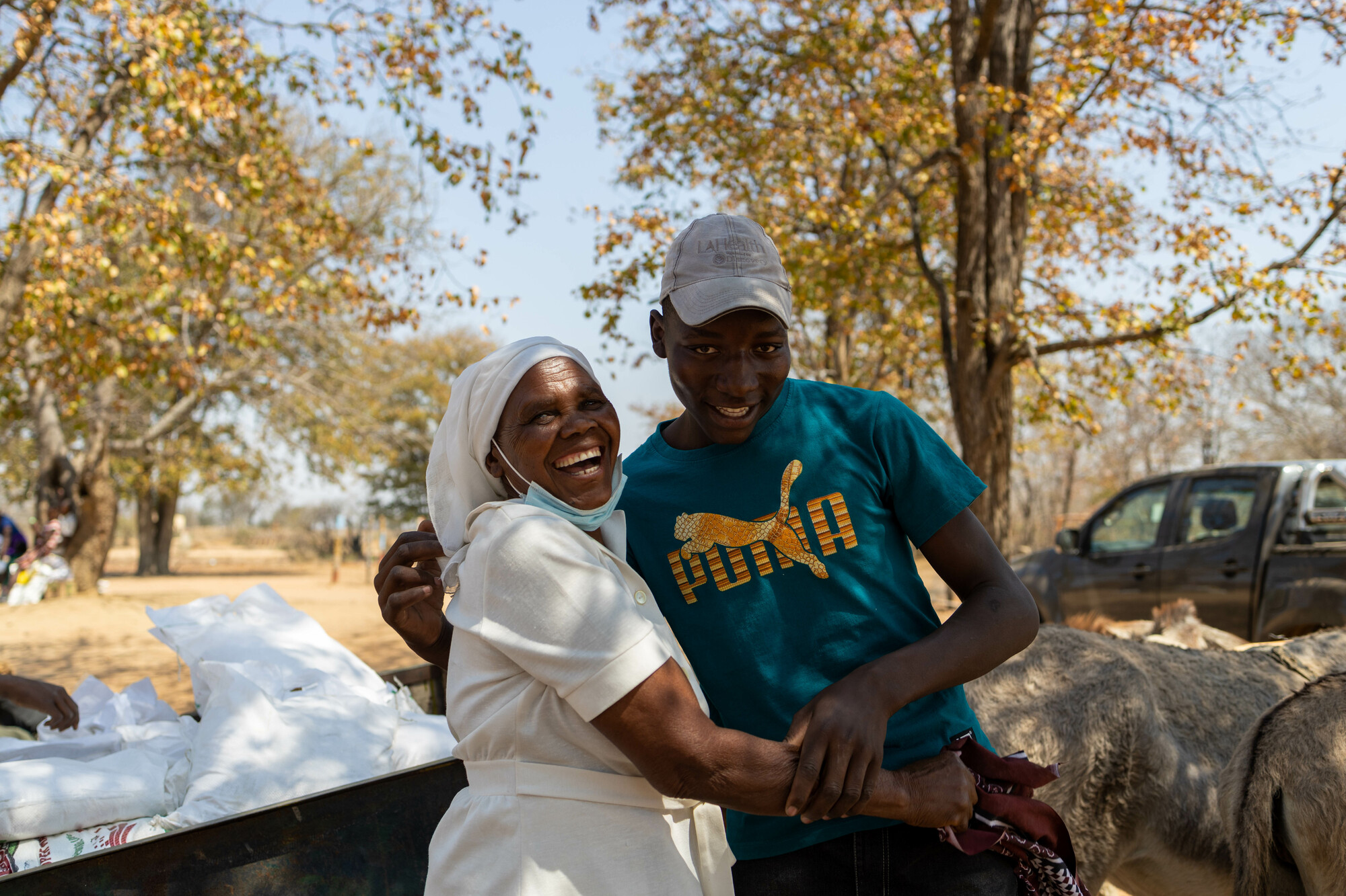 A woman and man smiling at a food distribution in Zimbabwe.