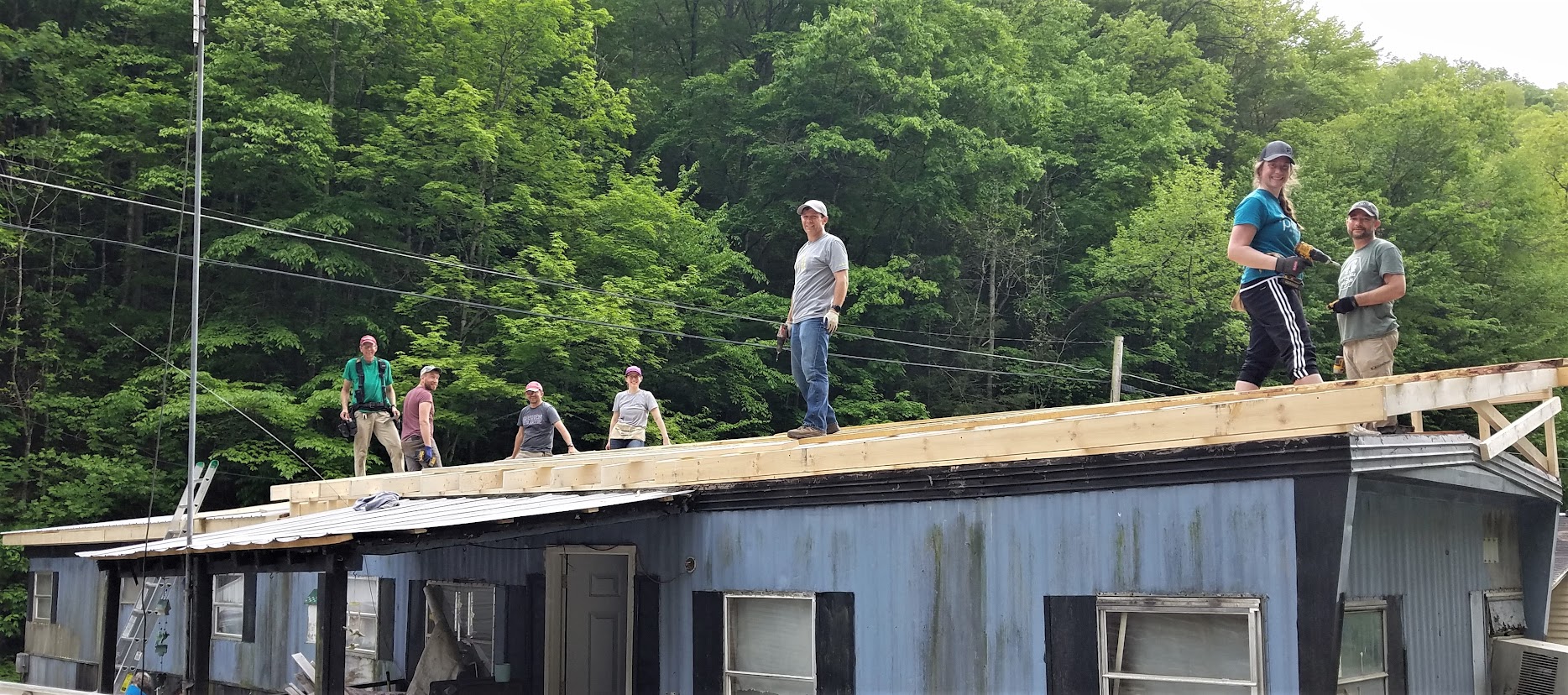 A group of 7 people working on a roof