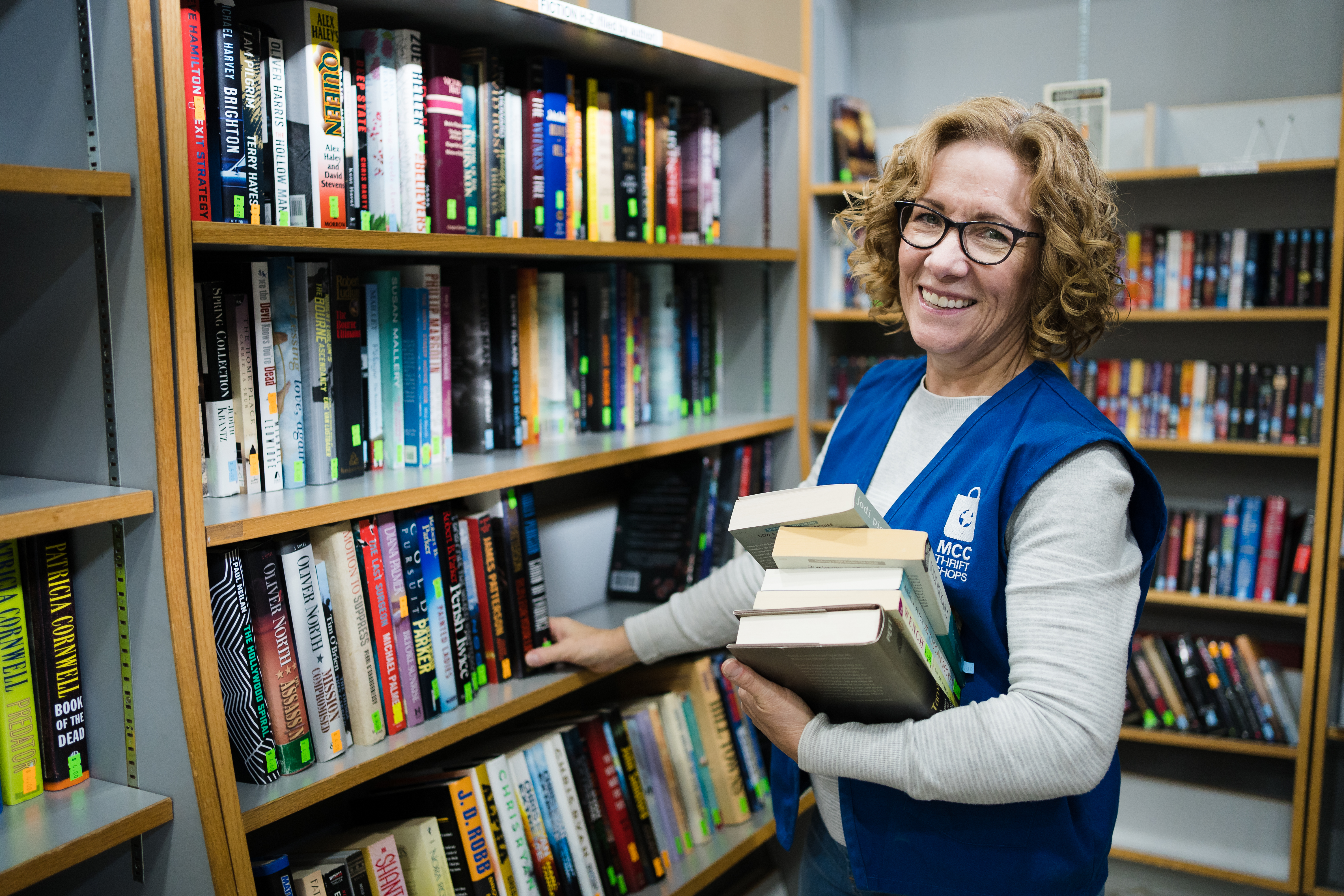 Volunteer Trudy Leiding restocks and organizes the shelves of the book department at the Calgary MCC Thrift Shop.