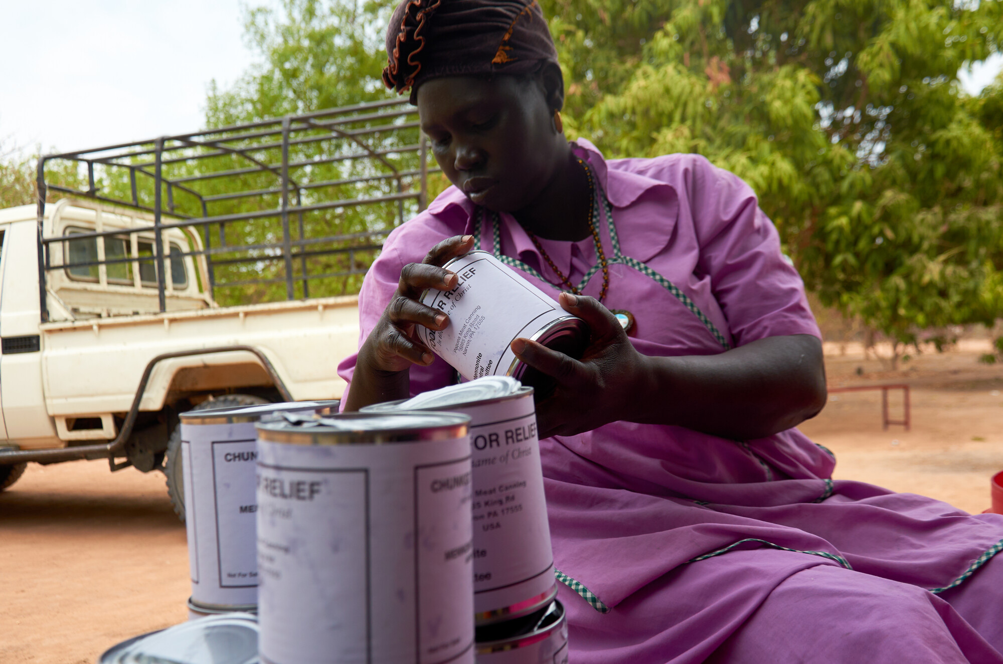 A woman holding cans of MCC canned meat