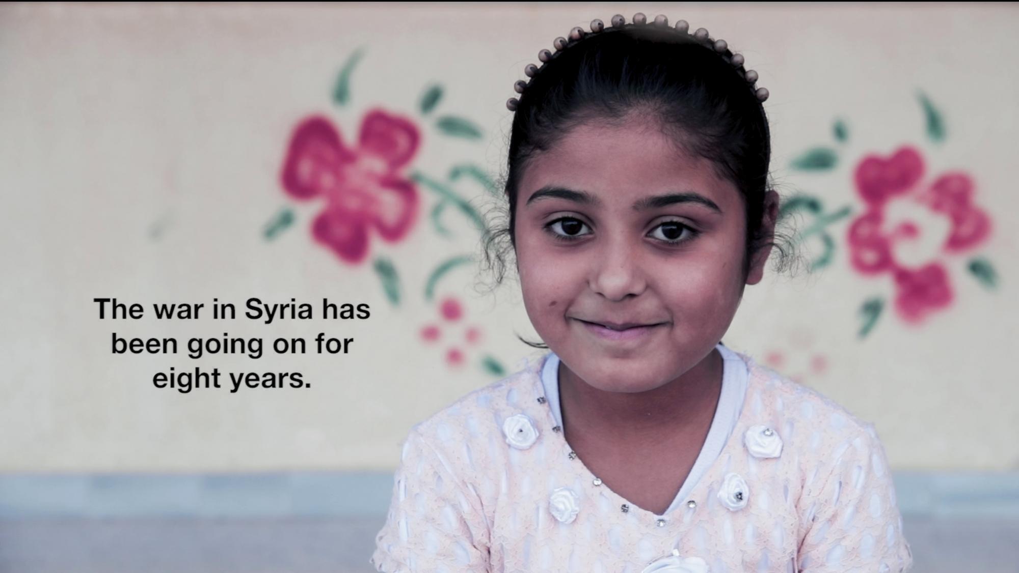 A screenshot from a video of a young Syrian girl. There is next on the screen that reads, "The war in Syria has been going on for 8 years."