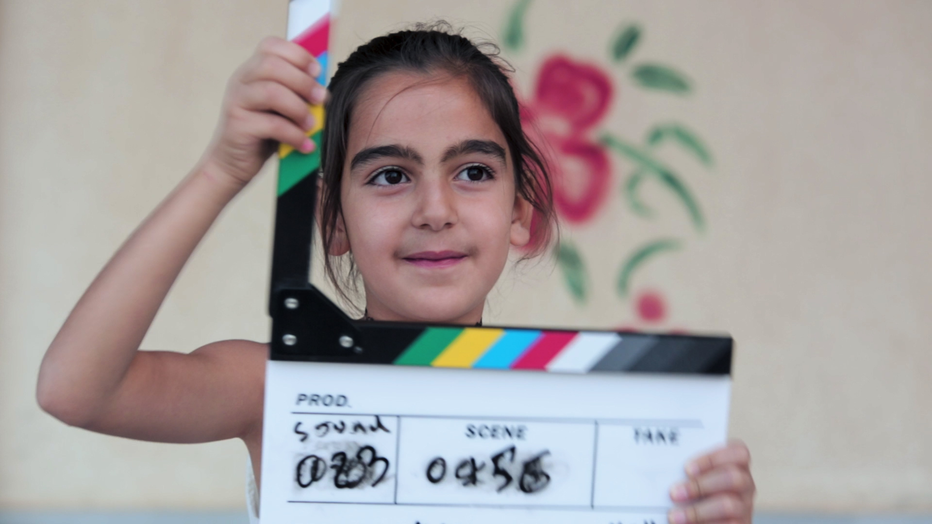 A young Syrian girl holds a clapperboard