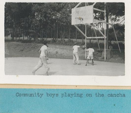 A black and white photo from the 1940s of people playing basketball on an outdoor court