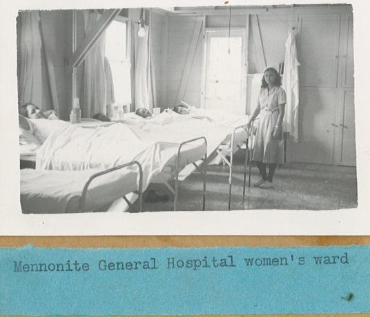 A black and white photo from 1940 of a woman standing near several patients' beds