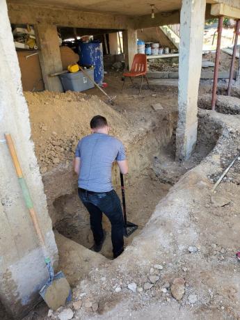 A man works in a hole in a construction site