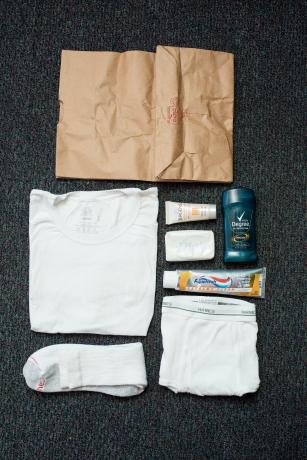 Hygiene items and a brown paper bag laid out neatly on the floor