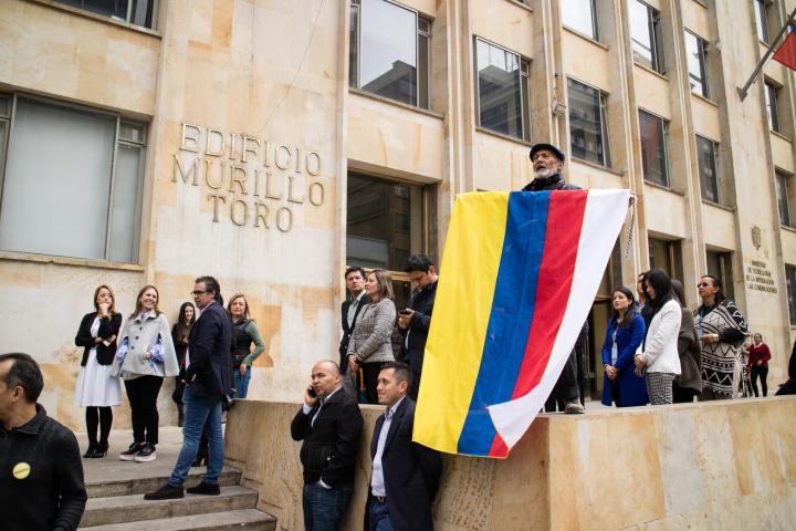  man holds a Colombian flag with an added white stripe to represent peace.
