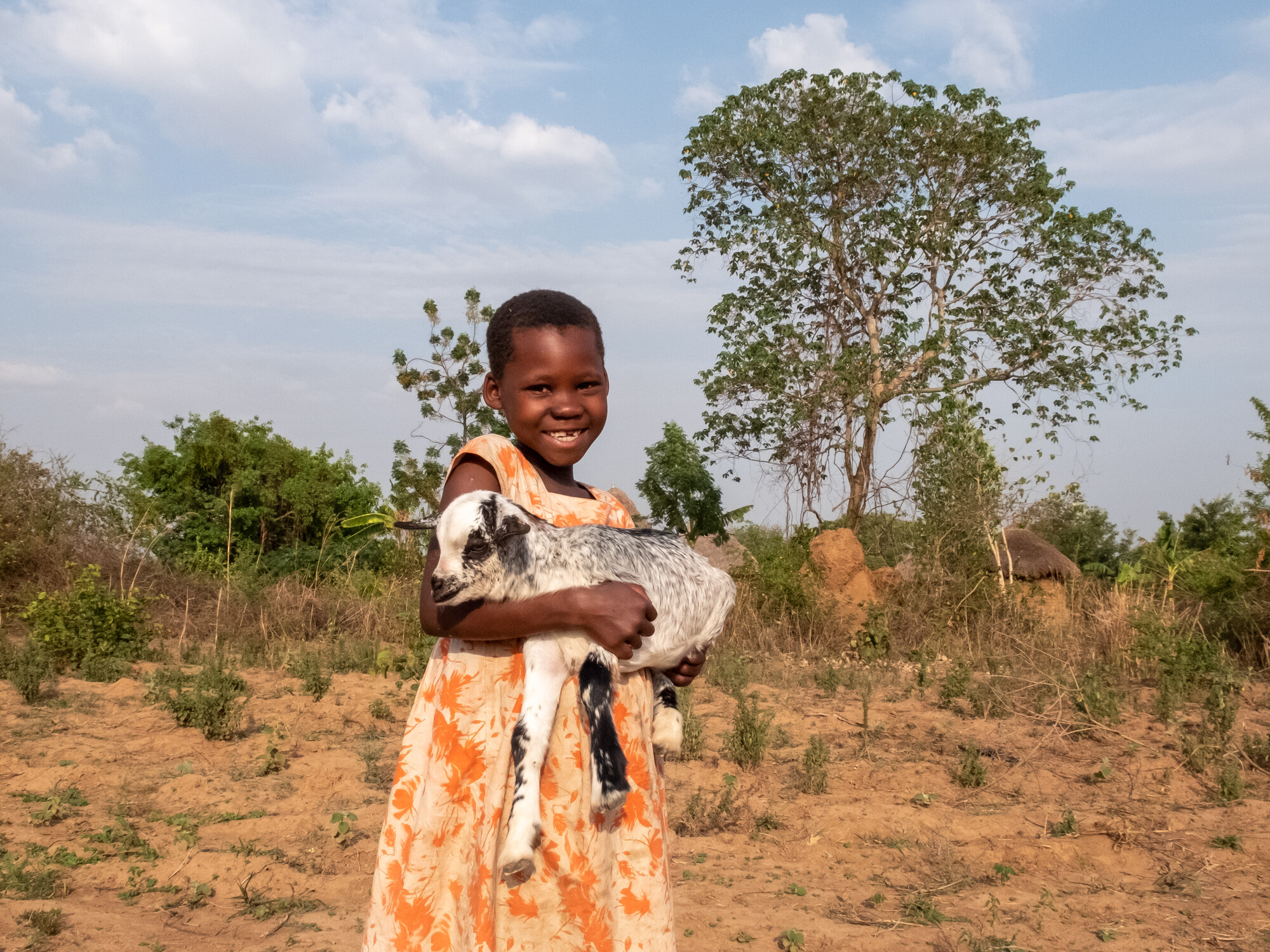Jerrn Ipene holds a baby goat at a farm in Uganda.